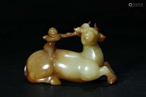 A PALE CELADON/RUSSET JADE CARVED BOY RIDING DEER