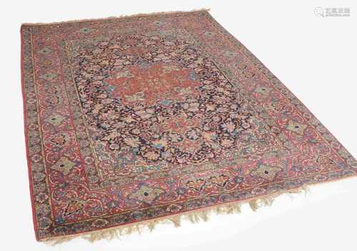 IsfahanZ-Persien, um 1910. Dichtes florales Werk. Im nachtblauen Mittelfeld ruht ein rotes