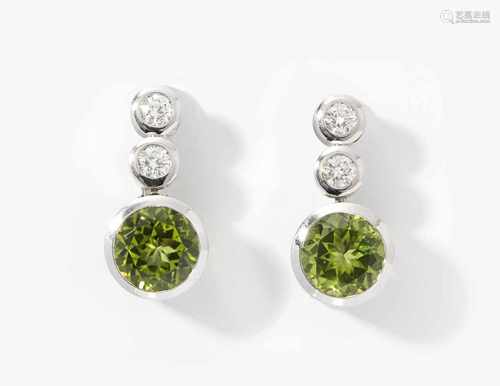 Peridot-Brillant-OhrclipsFrischknecht, St. Gallen. 750 Weissgold. 2 rund fac. Peridots zus. 4 ct mit