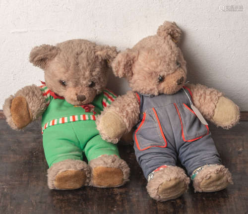 Zwei Teddybären, Steiff (20. Jahrhundert), bekleidet, H. ca. je 37 cm. Gebrauchsspuren.