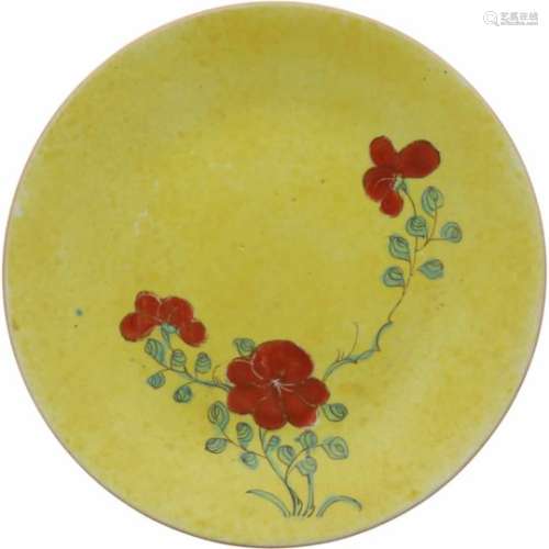 Een porseleinen bord met geel fond en beschildering van bloemen. China, 19e eeuw.Ø 25,5 cm.A