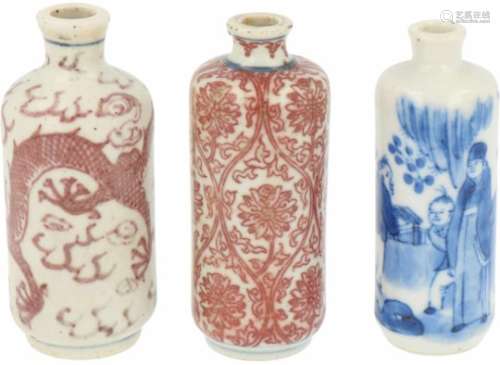 Een lot van drie porseleinen snuff bottles w.o. twee met 'iron red' decor. China, 19e eeuw.Afm. H: 8