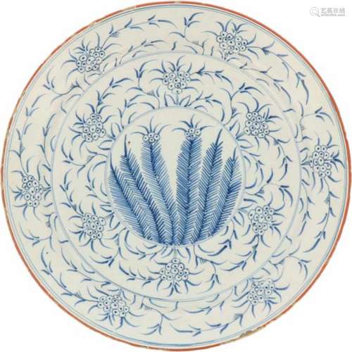 Een aardewerk schotel met bloemen decor. Ca. 1800.Randschade. Ø 33,5 cm.An earthenware dish with