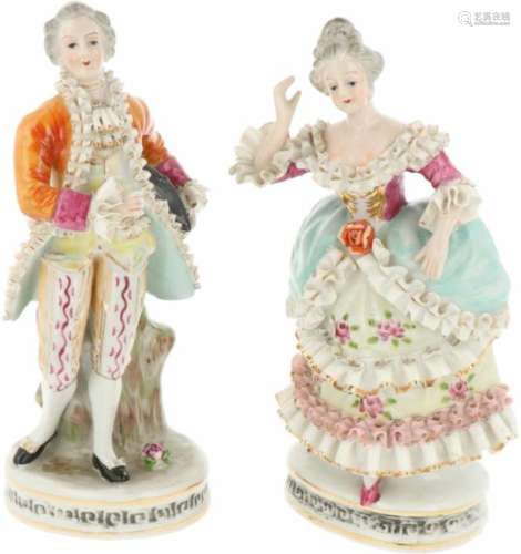 Een set van twee porseleinen beelden in de vorm van een feestelijk geklede man en vrouw, gemerkt