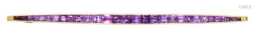 A CARTIER BAR BROOCH, SECOND QUARTER 20TH C with a line of calibre cut amethysts in plain gold