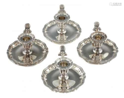 A SET OF FOUR VICTORIAN SILVER CHAMBERSTICKS with fluted sconce and shaped pan, nozzle and