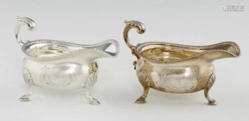 A PAIR OF GEORGE III SILVER SAUCE BOATS with gadrooned rim and leaf capped flying handle, on hoof