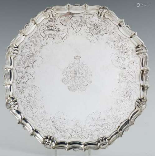 A GEORGE II SILVER SALVER engraved with armorials and baskets of fruit, on four volute feet, 45cm