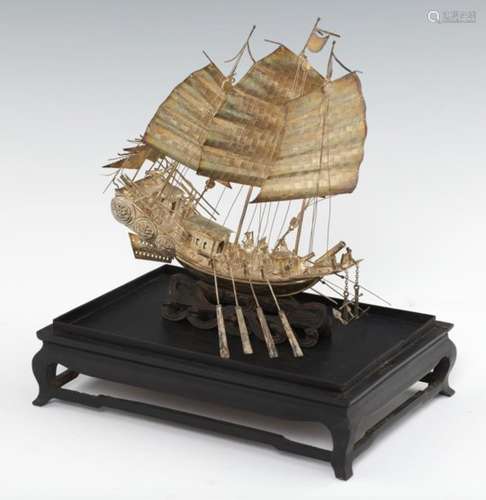 A CHINESE EXPORT SILVER MODEL OF A WAR JUNK, C LATE 19TH C on wave carved wood stand, 24cm h, marked