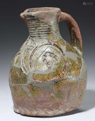 A MEDIEVAL ENGLISH GREEN GLAZED EARTHENWARE JUG, LATE 13TH-EARLY 14TH C of sandy red-brown fabric