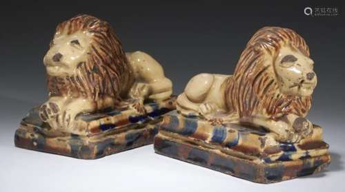 A PAIR OF SCOTTISH EARTHENWARE MODELS OF RECUMBENT LIONS, MID 19TH C cream, buff and ochre glazes,