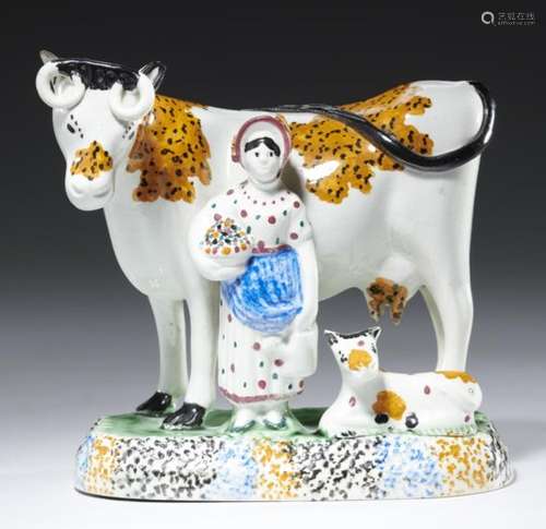 A YORKSHIRE PRATTWARE MILKMAID AND COW GROUP, C1820 with sponged decoration and typical mottled