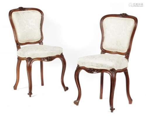 A PAIR OF VICTORIAN CARVED WALNUT SIDE CHAIRS, C1860 with padded cartouche back++One chair with