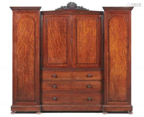 A WILLIAM IV BREAKFRONT PLUM PUDDING MAHOGANY WARDROBE, C1830-40 with carved anthemion crest flanked