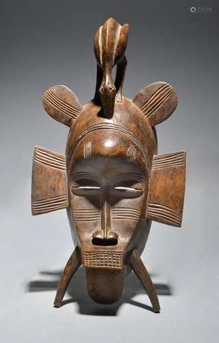 A Senufo kpelie mask Ivory Coast with a bird surmo…