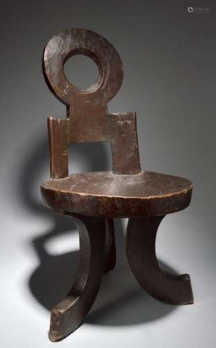 An Ethiopian chair with carved lines to the back, …