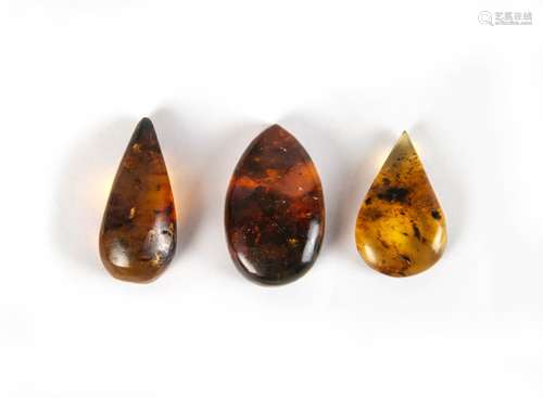 GROUP OF THREE BLUE-GREEN AMBER PIECES