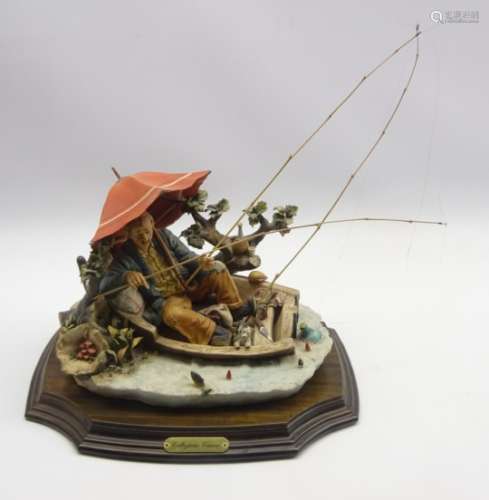 Large Capodimonte figure of a fisherman in a boat holding an umbrella,