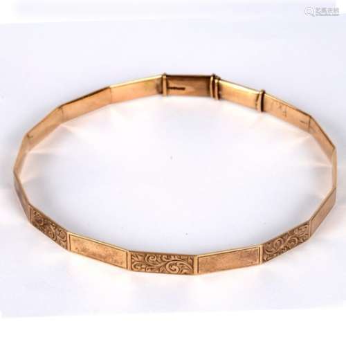 A 9ct gold arm bangle, of polygonal shape with alternate plain and engraved panels,