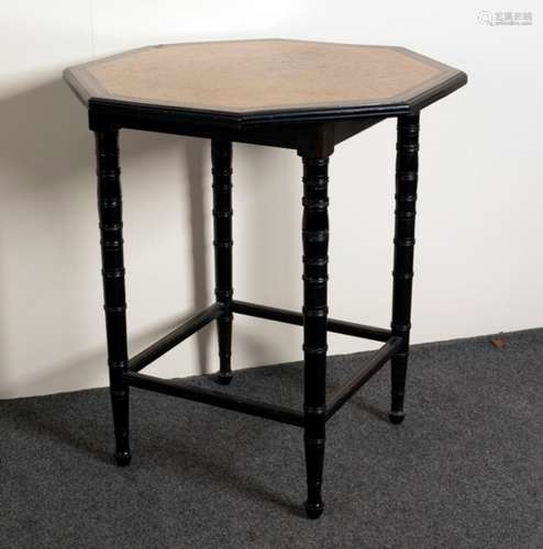 An Edwardian octagonal table with burr yew top and ebonised borders and ring turned supports with