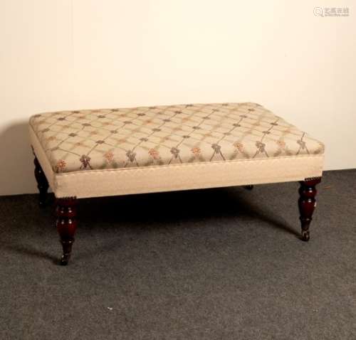A low upholstered stool on turned legs,