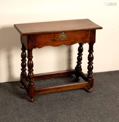 An oak table with shaped frieze on baluster turned legs,