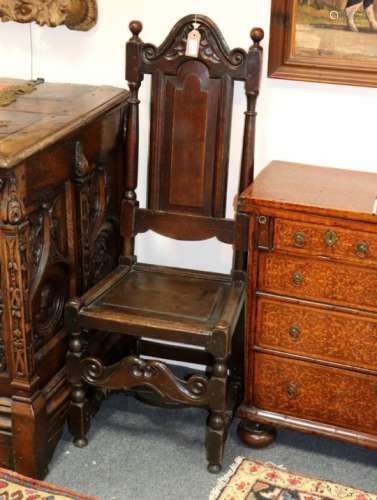 A 17th Century style high back chair with arch-top and solid panel splat and seat,