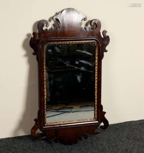 A small mahogany wall mirror with carved ear pieces,