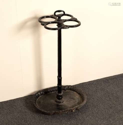 A cast iron stick stand, the four apertures to a central support set on an oval base,