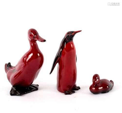 A Royal Doulton flambé figure of a duck, 16cm high, a penguin, 15cm high and a swimming duck,