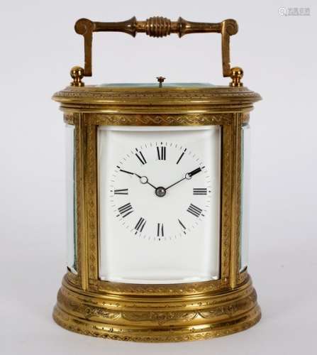 A gilt brass carriage clock in an oval engraved case,