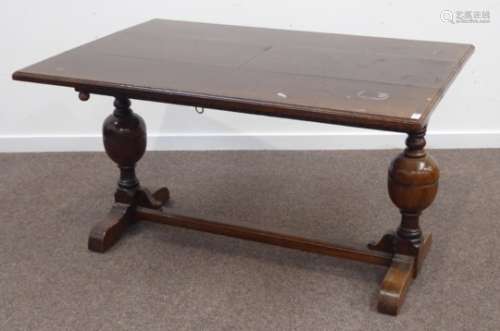 Early 20th century oak extending dining table, twin baluster supports joined by a singe stretcher,