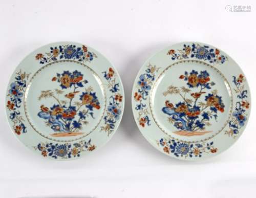 A pair of Chinese Imari style plates in overglaze blue enamels painted with birds amongst peonies