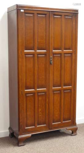 Early 20th century oak hall wardrobe, canted top and sides surrounding two beveled paneled doors,