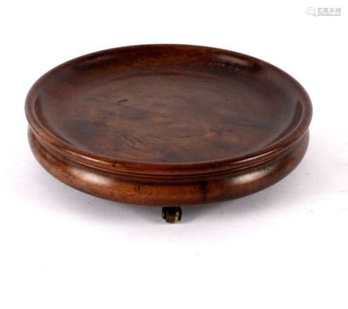 A Georgian circular mahogany coaster on three barrel feet,