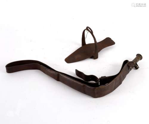 A leather shot pouch with brass gauge and a wrought iron stirrup with shoe support