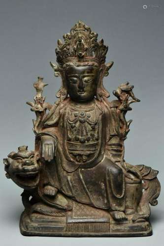 A MING BRONZE FIGURE OF GUANYIN SEATED ON A LION