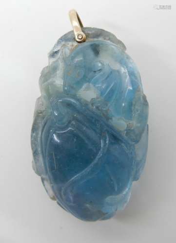 AN ORIENTAL CARVED FLUORITE PENDANT carved with a small mammal with a bushy tail among fruiting