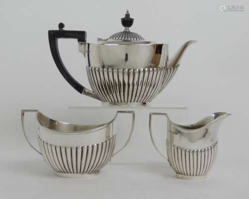 A THREE PIECE SILVER TEA SERVICE by Roberts & Belk, Sheffield 1912, of oval form with half ribbed