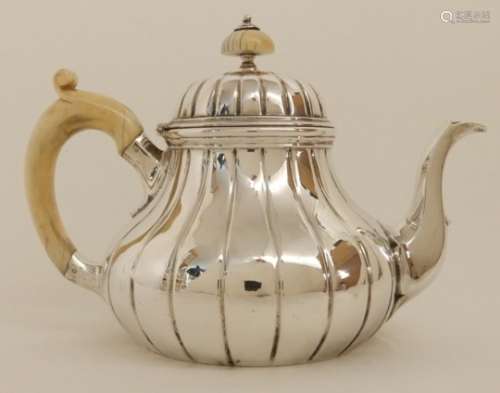 A VICTORIAN SILVER TEAPOT by Robert Garrard, London 1855, of bulbous baluster form with ribbed body,