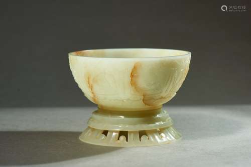 A CELADON JADE 'BUDDHA' BOWL AND STAND