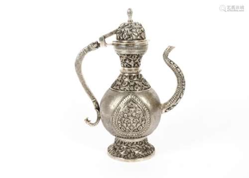 A 19th Century Indian white metal ewer, unmarked, of baluster form profusely embossed with flowers
