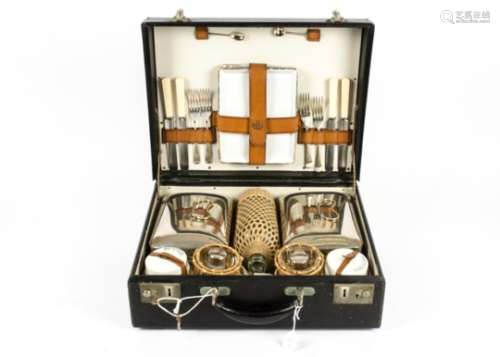 A picnic hamper for four, with a fitted interior, comprising cutlery, plates, cups, food containers,