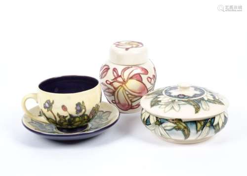 Three examples of Moorcroft pottery, a covered pot c.2002 designed by Anji Davenport, cup and saucer