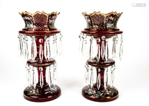 A pair of Edwardian cranberry glass table lustres, having gilt and enamel floral decoration and