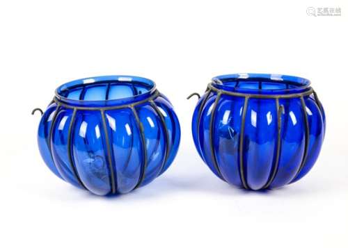 Two blue glass candle holders, of circular ribbed form, with metal suspenders and chains, height