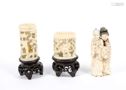 A late 19th Century Asian carved ivory couple, the woman putting her arms around the man, marks to