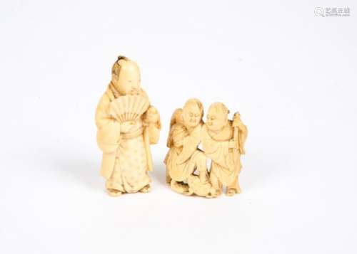 Two Meji period Japanese ivory okimonos, carved as a figure holding a fan, height 6 cm and a pair of