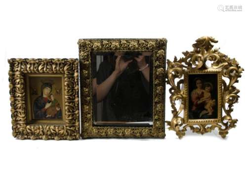 Two Madonna and child studies in gilt wood frames, together with a metalwork mirror with bevelled