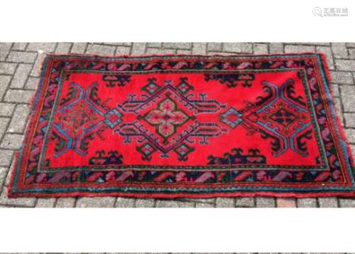 A 20th Century Turkish rug, green, blue and red border with three scrolling motifs to the centre, 94